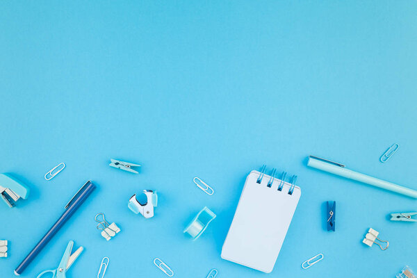 Вид сверху плоский стол в стиле дизайнерской школы и канцелярских принадлежностей с бирюзово-синим цветом бумаги на фоне минимального стиля. Шаблон для женского блога
