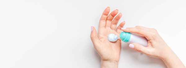 Woman moisturizing hands skin with cosmetic cream lotion copy space on white background in minimalism style. Concept template feminine blog social media beauty concept. Long wide banner