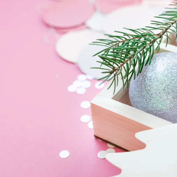 新年圣诞节圣诞假期庆典作文珍珠装饰玩具球木箱冷杉树枝闪光纸屑粉红色纸背景复制空间方形模板问候明信片文本设计 — 图库照片