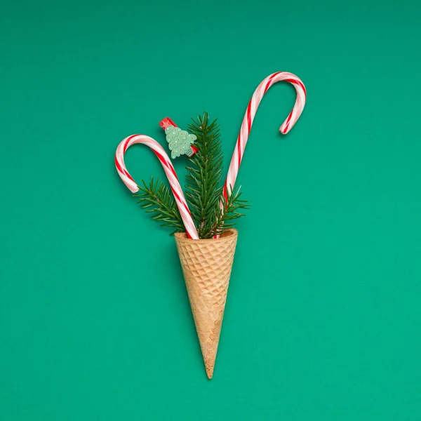 New Year Christmas Xmas holiday party celebration waffle cone candy canes fir tree branch copy space green color paper background. Square Template greeting card 2019
