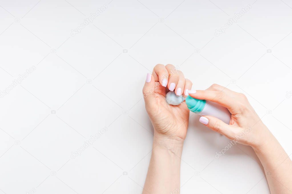 Creative image of woman moisturizing her hands skin with cosmetic cream lotion with copy space on white background in minimalism style. Concept template feminine blog, social media, beauty concept