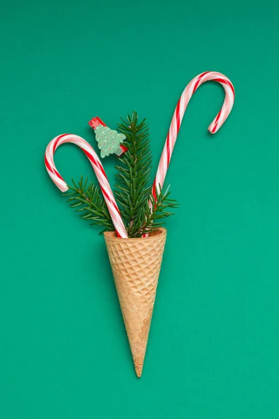 New Year Christmas Xmas holiday party celebration waffle cone candy canes fir tree branch copy space green color paper background. Template greeting card 2019