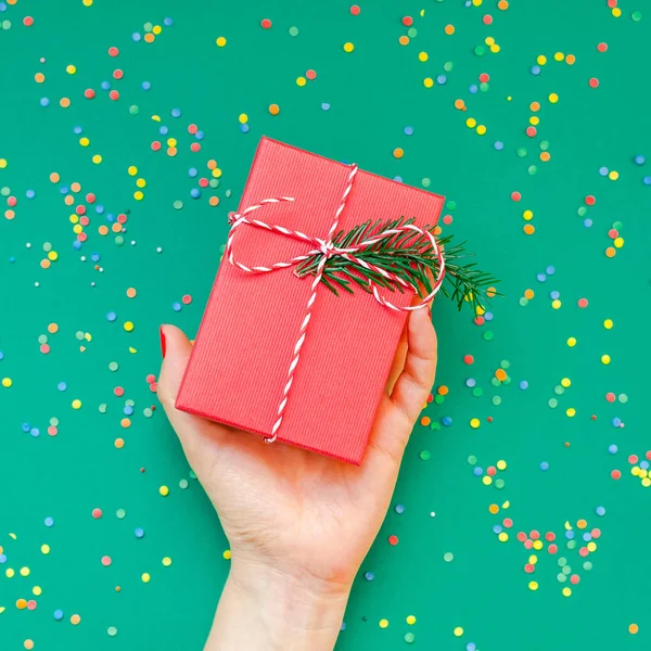 新年やクリスマスの上を表示クリスマス休日お祝い女性手赤いマニキュア プレゼント ギフト ボックス コピー スペース緑色用紙の背景を保持します グリーティング カードのテンプレート — ストック写真