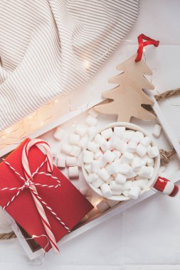 Yeni yıl veya Noel düz üstten görünüm ile sıcak kakao kahve çikolata şekerleme kupa Xmas tatil kutlama kırmızı mevcut kutusu ahşap tepsi ışıkları ile yatakta yatıyordu. Kavram blog sosyal medya 2019