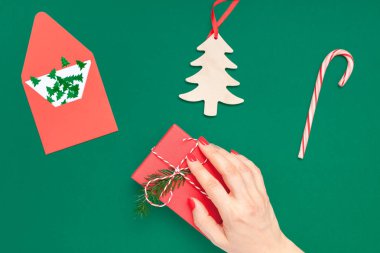 Yeni yıl veya Noel top Xmas tatil kutlama kadın el Kırmızı manikür mevcut hediye kutusu kopya alanı yeşil renk Kağıt arka plan tutan görüntüleyin. Şablon tebrik kartı