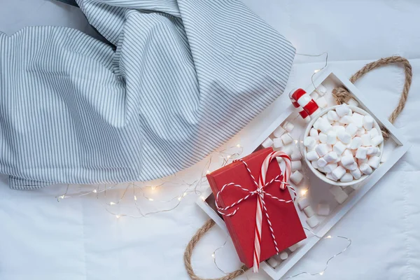 新年やクリスマスのフラット トップ ビューのレイアウトをカカオ コーヒー チョコレート マシュマロ マグカップ クリスマス休日お祝い赤いプレゼント ボックス ライトが付いているベッドの木製皿のホットで — ストック写真