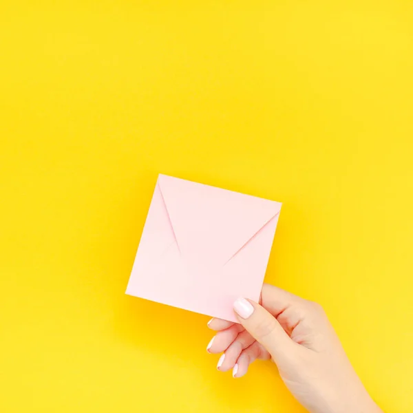 妇女手与柔和的美甲持有小爱千禧年粉红色的字母与复制空间上大胆的黄色背景创意最小的风格 方形概念模板情人节女性博客 — 图库照片