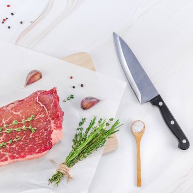 Yaratıcı en iyi görünüm düz yatıyordu taze çiğ sığır eti striploin biftek biberiye kekik otlar sarımsak biber mantar et beyaz mermer masa arka plan kopya alanı. Kare kavramı yemek yiyecek et hazırlama