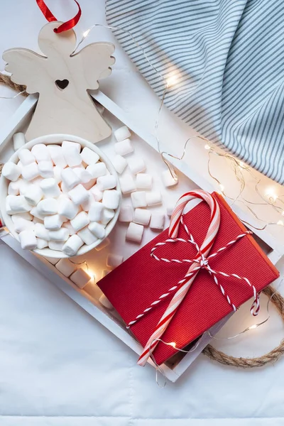 新年やクリスマスのフラット トップ ビューのレイアウトをカカオ コーヒー チョコレート マシュマロ マグカップ クリスマス休日お祝い赤いプレゼント ボックス ライトが付いているベッドの木製皿のホットで — ストック写真
