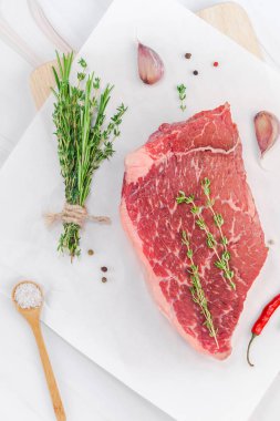 Yaratıcı üstten görünüm taze çiğ sığır eti striploin biftek biberiye kekik otlar sarımsak biber mantar beyaz mermer masa arka plan kopya alanı ile üzerinde düz yatıyordu. Gıda hazırlama pişirme kavramı