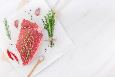 Yaratıcı üstten görünüm taze çiğ sığır eti striploin biftek biberiye kekik otlar sarımsak et biber mantar beyaz mermer masa arka plan kopya alanı ile düz yatıyordu. Gıda et hazırlık pişirme kavramı