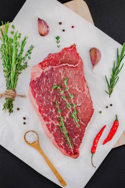 Yaratıcı üstten görünüm taze çiğ sığır eti striploin biftek biberiye kekik otlar sarımsak biber mantar kopya alanı siyah zemin üzerine düz yatıyordu. Gıda hazırlama pişirme kavramı