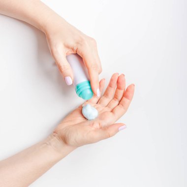 Yaratıcı kare görüntü kadın minimalizm tarzı beyaz arka plan üzerinde kopya alanı ile kozmetik krem losyon ile el cildi nemlendirici. Kavram şablon kadınsı blog sosyal medya güzellik kavramı