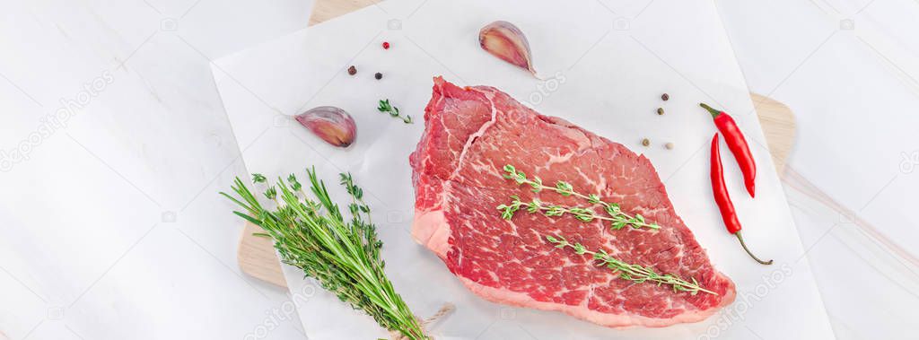 Creative Top view flat lay of fresh raw beef meat striploin steak with rosemary thyme herbs garlic pepper mushrooms on white marble table copy space. Food preparation cooking concept Long wide banner