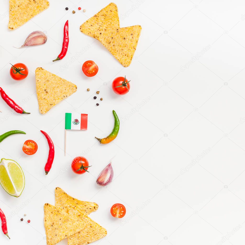 Creative Top view flat lay of fresh mexican food ingredients with tortilla nachos chips garlic pepper lime tomatoes on white table background with copy space. Food preparation cooking square frame