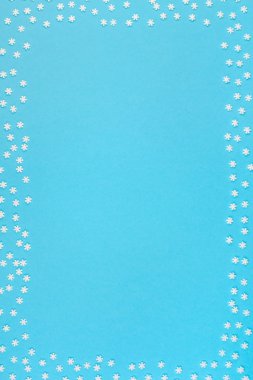 Yaratıcı üst düz yatıyordu kış çerçeve görüntüleyin. Yıldönümü tasarım davetiye kartları için küçük beyaz kar taneleri pastel mavi arka plan kopya alan minimalizm şablon kavram kış desen yapılmış
