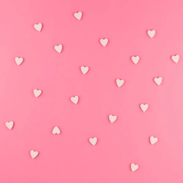情人节图案背景平面放置粉红色心形糖果的顶部视图散落在粉红色广场背景爱婚礼理念 — 图库照片
