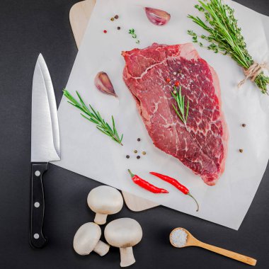 Yaratıcı üstten görünüm taze çiğ sığır eti striploin biftek biberiye kekik otlar sarımsak biber mantar et siyah arka plan ile kopya alanı düz yatıyordu. Kare kavramı yemek yiyecek et hazırlama