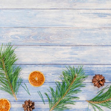 Yeni yıl Noel desen düz el yapımı elişi doku ile köknar ağacı çam kozalakları dalları Xmas tatil kurutulmuş portakal mavi ahşap arka plan kopya alanı şablonu için tebrik kartı üstten görünüm yatıyordu