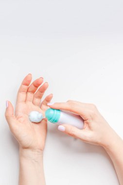 Minimalizm tarzı beyaz arka plan üzerinde kopya alanı ile kozmetik krem losyon ile el cildi nemlendirici kadın yaratıcı görüntü. Kavram şablon kadınsı blog, sosyal medya, güzellik kavramı