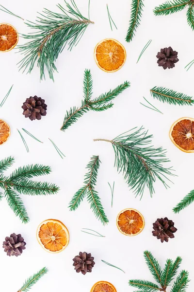 New Year Christmas pattern flat lay top view Xmas holiday handmade handicraft texture with fir tree pine branches cones dried oranges white background copy space Template for greeting card text design