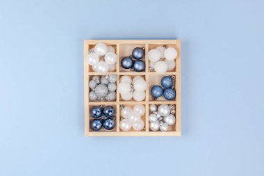 Yeni yıl veya Noel desenli düz üstten görünüm Xmas tatil kutlama dekoratif oyuncak topları metin tasarım ahşap kutu mavi Kağıt arka plan kopya alanı şablonu çerçevesinde tebrik kartı için parıldıyor yatıyordu