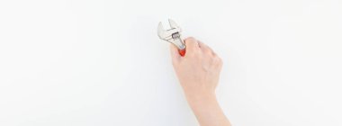 Kadın el minimalizm tarzı beyaz arka plan üzerinde izole kopya alanı ile somun anahtarı tutan pastel manikür Lehçe ile yaratıcı geniş uzun afiş. Onarım veya iyileştirme feminizm kavramı