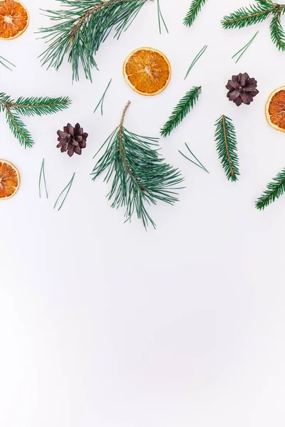 New Year Christmas pattern flat lay top view Xmas holiday handmade handicraft texture with fir tree pine branches cones dried oranges white background copy space Template for greeting card text design