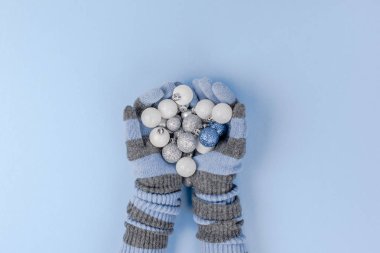 Yeni yıl veya Noel desenli düz üstten görünüm Xmas tatil kutlaması çerçevesinde örme eldiven mavi Kağıt arka plan kopya alanı şablonu için tebrik kartı metin tasarım elinde dekoratif oyuncak topları lay