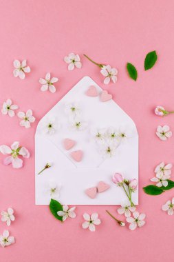 Yaratıcı düz kavramı üstten görünüm boş mektup zarfının, bahar çiçekleri yatıyordu ve kalpler şeker ile bin yıllık pembe arka plan üzerinde en az tarzı, Sevgililer kartları için şablon alanı kopyalayın