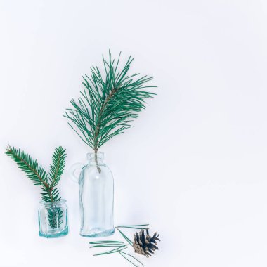 Yeni yıl veya Noel kompozisyon düz yatırın üstten görünüm Xmas tatil kutlaması el yapımı elişi küçük cam şişeler için tebrik kartı köknar ağacı çam dalları beyaz arka plan kopya alanı şablonu