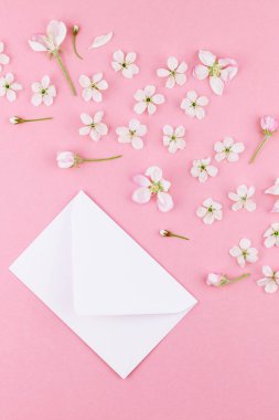 Yaratıcı düz kavramı üstten görünüm boş mektup zarfının lay ve en az tarzı, kutlama, Sevgililer kartları için şablon alan bahar kiraz ağacı çiçekleri ile bin yıllık pembe arka plan üzerinde kopyalama