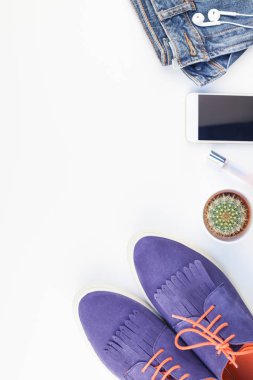 Düz beyaz arka plan kopya alanı ile kulaklıktan süet ayakkabı, kot, bilezik kaktüs ve akıllı telefon yatırın. Kadın rahat kıyafet havai görünümü. Trendy hipster bak üstten görünüm
