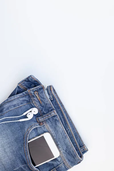 Επίπεδη Θέσει Μπλε Τζιν Και Smartphone Ακουστικά Που Απομονώνονται Λευκό — Φωτογραφία Αρχείου
