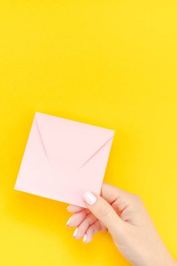 Kadın el pastel manikür kopya alanı kalın sarı zemin üzerine küçük aşk bin yıllık pembe mektubu yaratıcı minimal tarzda holding ile. Kavram şablon Sevgililer tatil kadınsı blog için