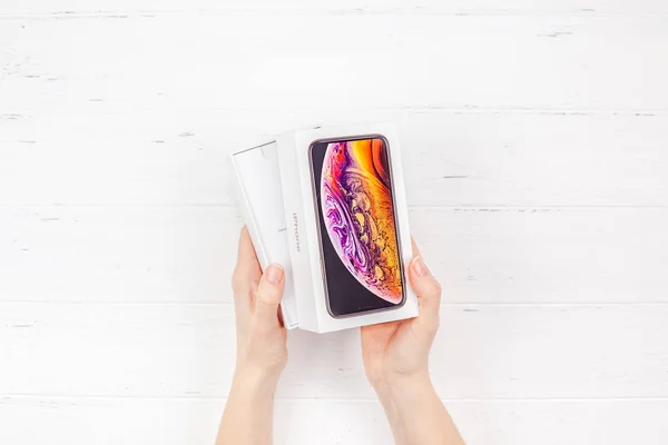 ベルリン ドイツ 2018 女性の手が白い木製の背景に対してアップル Iphone の最新スマート フォンのカラフルなボックスを保持します コピー スペースとボックス化解除の概念 — ストック写真