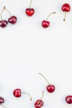 Minimal tarzda beyaz arka plan üzerinde izole kopya alanı ile taze olgun kiraz desen düzeninin yaratıcı üstten görünüm. Yaz eğlenceli ve sağlıklı beslenme kavramı. Metin veya gıda tasarımınız için şablon