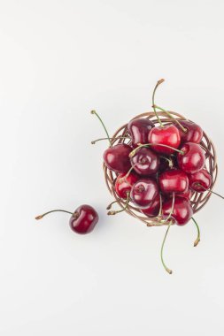 Yaratıcı üstten görünüm taze olgun kiraz kopya alanı ile küçük bir sepet içinde beyaz arka plan en az stili izole. Yaz eğlenceli ve sağlıklı beslenme kavramı. Metin veya gıda tasarımınız için şablon