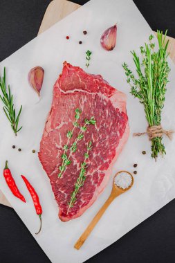Yaratıcı üstten görünüm taze çiğ sığır eti striploin biftek biberiye kekik otlar sarımsak biber mantar kopya alanı siyah zemin üzerine düz yatıyordu. Gıda hazırlama pişirme kavramı