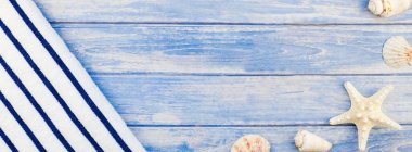 Uzun geniş afiş düz yaz seyahat tatil kavramı yatıyordu. Deniz ve deniz yıldızı pastel mavi ahşap plakalar ile arka plan kopya alanı rustik tarzı çerçeve şablonu metin üstten görünüm havlu Flip floplar