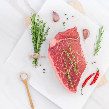 Yaratıcı en iyi görünüm düz yatıyordu taze çiğ sığır eti striploin biftek biberiye kekik otlar sarımsak biber mantar et beyaz mermer masa arka plan kopya alanı. Kare kavramı yemek yiyecek et hazırlama