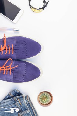 Düz beyaz arka plan kopya alanı ile kulaklıktan süet ayakkabı, kot, bilezik kaktüs ve akıllı telefon yatırın. Kadın rahat kıyafet havai görünümü. Trendy hipster bak üstten görünüm