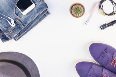 Düz beyaz arka plan kopya alanı ile kulaklıktan süet ayakkabı, kot, gri şapka, kaktüs ve akıllı telefon yatırın. Kadın rahat kıyafet havai görünümü. Trendy hipster bak üstten görünüm