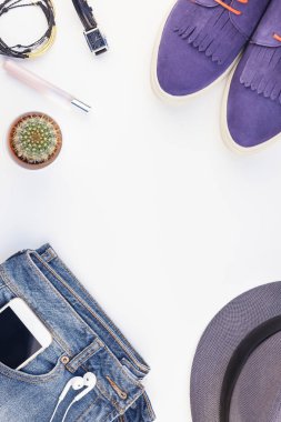 Düz beyaz arka plan kopya alanı ile kulaklıktan süet ayakkabı, kot, gri şapka, kaktüs ve akıllı telefon yatırın. Kadın rahat kıyafet havai görünümü. Trendy hipster bak üstten görünüm
