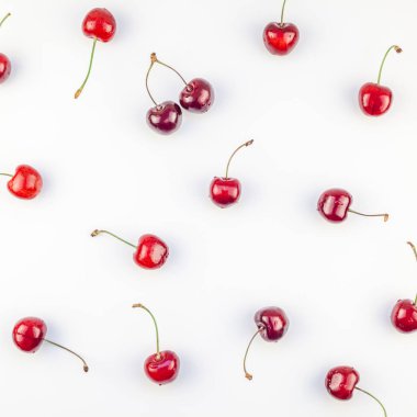 Üstten görünüm taze olgun kiraz desen düzeninin en az tarzında beyaz arka plan üzerinde izole kopya alanı ile kare. Yaz eğlenceli ve sağlıklı beslenme kavramı. Metin veya gıda tasarımınız için şablon