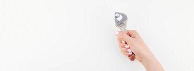 Kadın el minimalizm tarzı beyaz arka plan üzerinde izole kopya alanı ile somun anahtarı tutan pastel manikür Lehçe ile yaratıcı geniş uzun afiş. Onarım veya iyileştirme feminizm kavramı