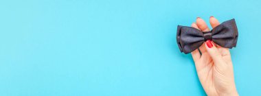 Yaratıcı flatlay üstten görünüm retro siyah papyon kadın eller turkuaz Kağıt arka plan kopya alanı. Erkekler sağlık bilinci ay babalar günü erkeklik kavramı blog sosyal medya geniş afiş uzun