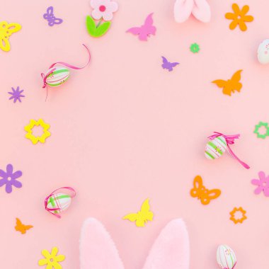 Yaratıcı Top View düzlük tatil kompozisyonu. Paskalya yumurtaları tavşan kulakları. Pembe kağıt arka plan üzerinde bahar çiçekleri.
