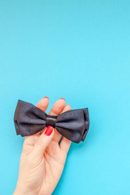 Yaratıcı flatlay üstten görünüm retro siyah papyon kadın eller turkuaz Kağıt arka plan kopya alanı. Erkek Sağlığı Farkındalık ay gün erkeklik kavramı blog sosyal medya babalar