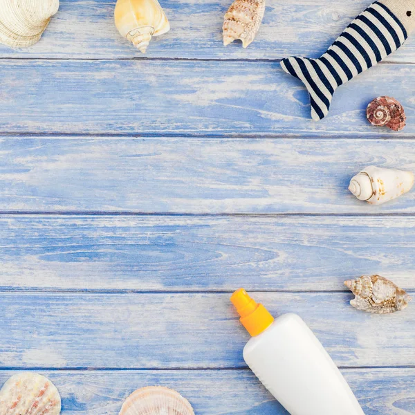 Yaratıcı düz yaz seyahat tatil kavramı yatıyordu. En iyi plaj havlu güneş kremi şişe flip flop deniz kabuklarını denizyıldızı pastel mavi ahşap plakalar arka plan kopya alanı mockup şablon metin görünümünü kare